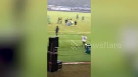 Fighting football fans spilling onto the pitch during game in Indonesia