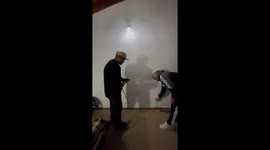 Friends struggle to mount mirror with short-corded drill