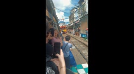 Train crashes into market stall parasol at Thailand's famous railway spot