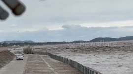 Cars speed up to escape tidal bore wave racing along river