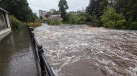 River Skell in Ripon North Yorkshire raging past the Water Rat Pub as rain continues