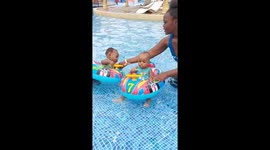 Toddler twins flip in baby floaters during first pool experience in Mombasa, Kenya