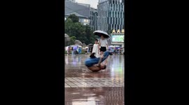 Street dancer busts impressive moves on wet pavement