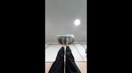 Woman keeps drum in the air with her feet to make a rhythm