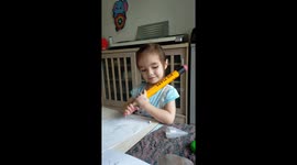 A little girl making big plans and using a giant pensil taken in Thailand.