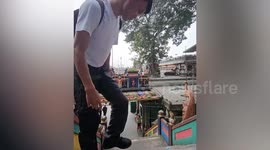 Wild monkey steals tourist's phone then records video of him from lamppost