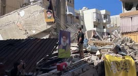 Local resident pays tribute to Hassan Nasrallah's picture amid rubble in Dahieh suburb