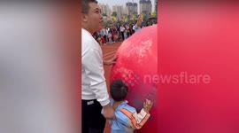 Father lifts son by his shirt to win ball race