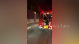 Tourist in superhero costume dances upside-down on red bus in Phuket