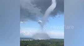 Thunder cracks as waterspout tornado churns along coast