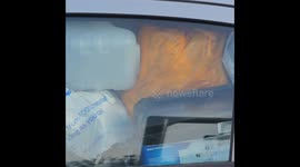 Rubbish filled car and driver parked at a famous Burger outlet, Car valet long overdue. Fraddon, Cornwall, UK