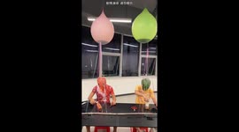 Two friends compete in bottle-toss game with water balloons in China