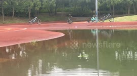 Bicyclist navigates deep water pool in Jiangsu, China