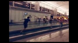 Ballet dancers dance on moving sidewalk in airport