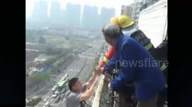 Firefighters rescue man hanging form top of a building