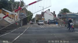Man runs across level crossing with pushchair