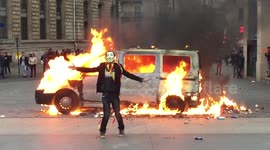 Masked man dances next to van on fire in Paris