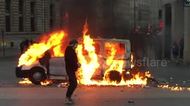 DUPLICATE Masked man dances next to van on fire in Paris