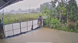 Driver ploughs through flooded road causing gate to topple over