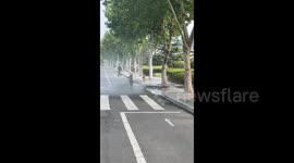 China: A Leaking Hydrant Splashes Water Around The Street
