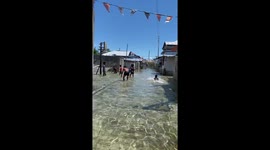 Locals play basketball in coastal town that is constantly flooded