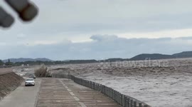 Tide chases cars by Qiantang River