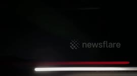 Time lapse of Aurora Borealis with occasional cars passing thru