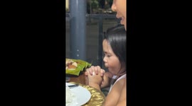 Cheeky girl grabs food while saying grace