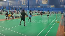 Badminton player falls on net