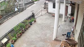 Woman takes a tumble when her skirt gets snagged climbing over wall