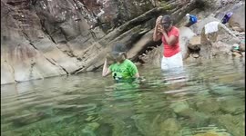 China: Two women wearing diving goggles each carried a large rock to the bottom of the lake