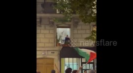France: A woman's response to a massive pro-Palestine march passing her home in Paris, France