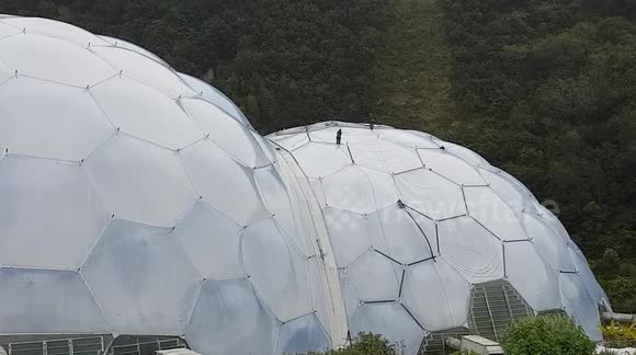 Eden Project work men with a couple of Mastic guns sealing around the edge of the double glazing .