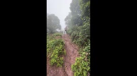 Chinese man navigates muddy mountain trail on stilts