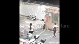 Hilarious moment woman gets stuck mid-air whilst trying to climb rising arm barrier