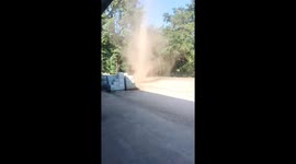 Twisty dust devil tornado tears through family's front yard