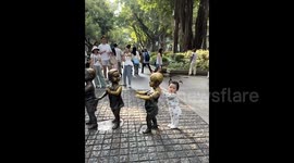 Adorable moment confused baby girl queues behind line of statue children in China