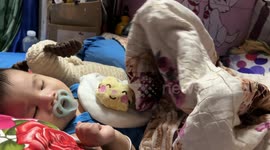This baby has a bizarre sleeping position... with her legs raised in the air