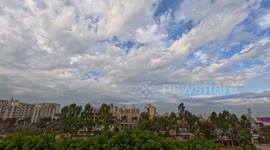 Time lapse of city fast moving traffic blue sky moving clouds