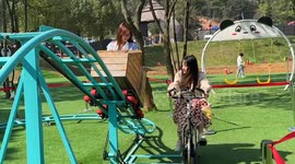 Parkgoer powers on bicycle-driven mini rollercoaster for friend
