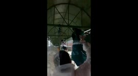 Locals walk on railings to cross Tropical Storm Trami flood