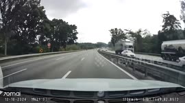 Burning lorry manoeuveres on highway and crashes with passing cars in Malaysia