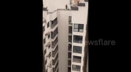 Kids dangerously playing on rooftop of 20th floor shouted at by neighbour from adjacent building