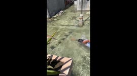Locals swim through streets in perennially flooded coastal village