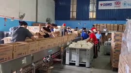 Volunteers pack food for Tropical Storm Trami survivors