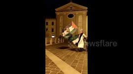 Italy: A guy on a scooter rides with a Palestinian flag in Italy