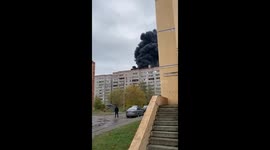 Woman continues to wash windows during apartment fire in Moscow