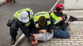 Police officers wrestle a far-right protester to the ground in London during a day of far-right and anti-racism protests
