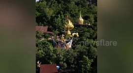 Golden dragon monument nestles on hillside Buddhist temple in Thailand