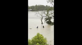 Residents navigate flooded fields after tropical storm Kristine hits Bicol